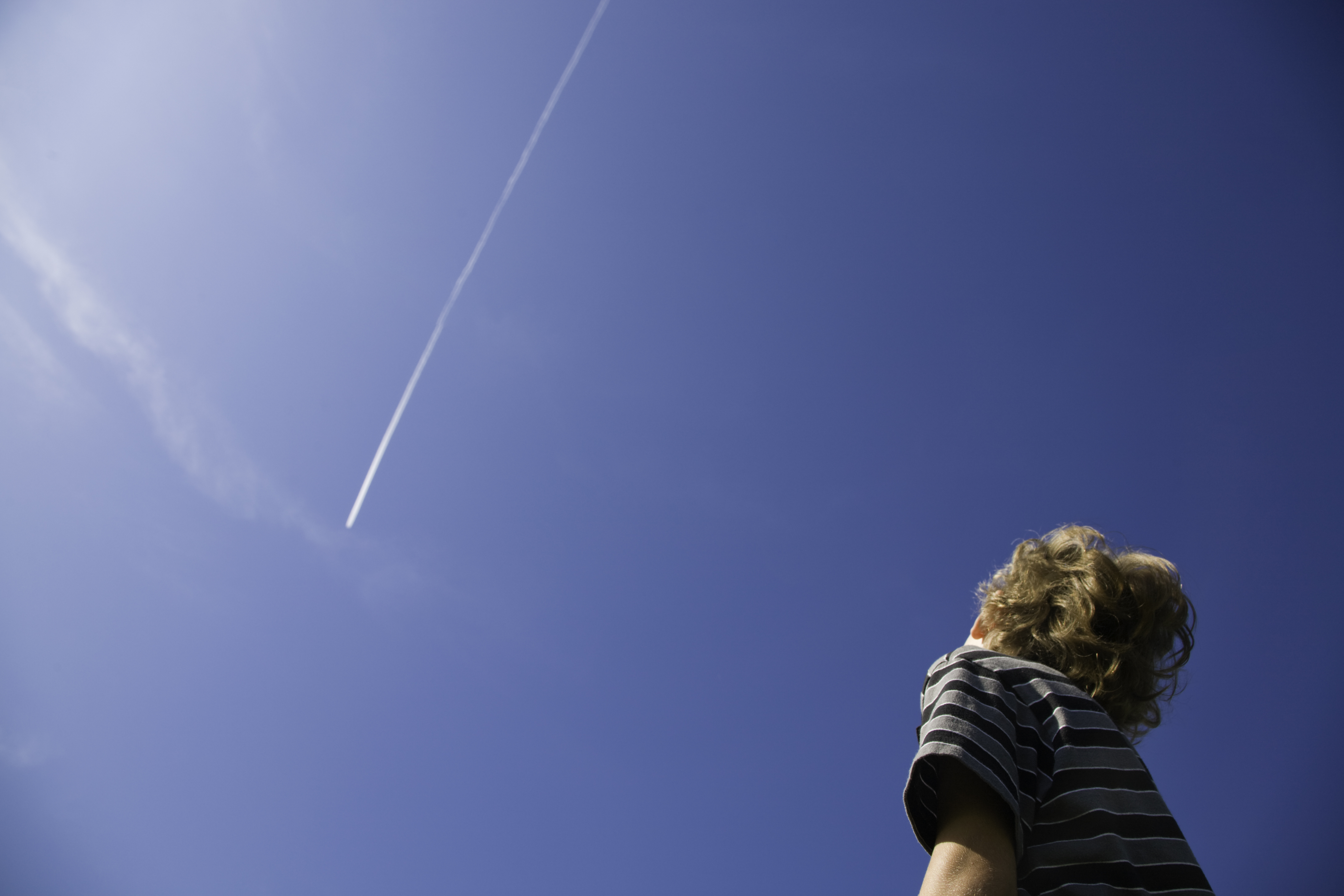 Boy Looking at Jet Contrail